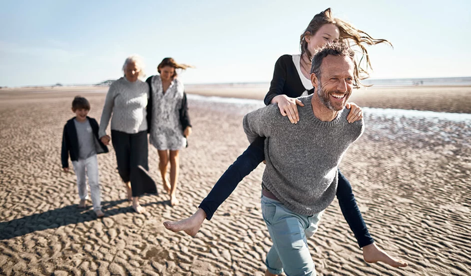 Glückliche Familie geht am Strand spazieren.